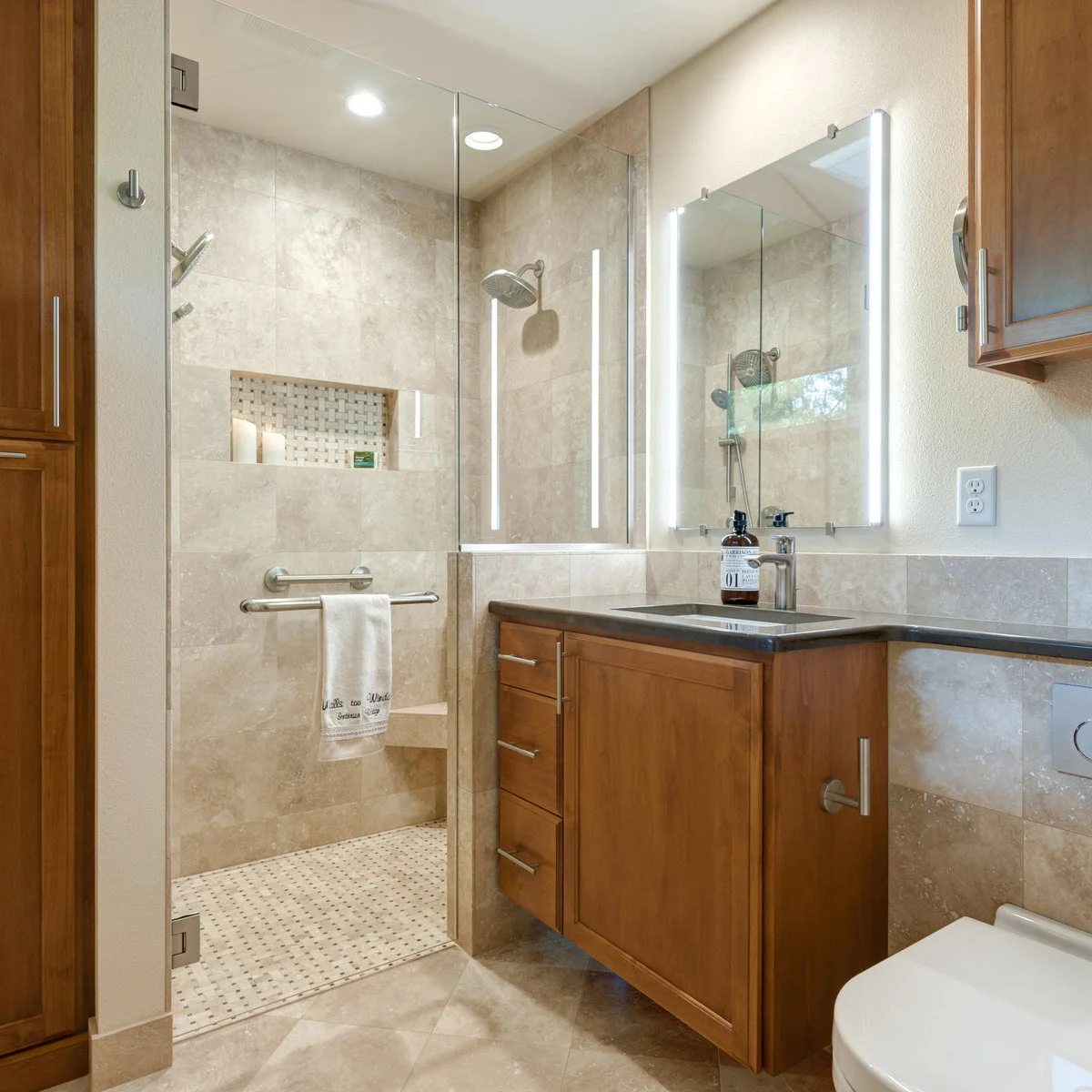 Pale tiled shower with a wide basketweave-backed niche beside a wood vanity