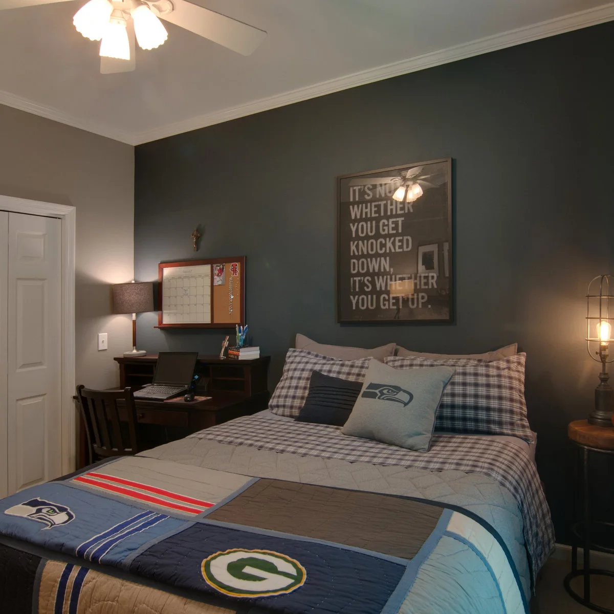 Teen bedroom with a dark desk, wall calendar and gray checked bedding beside the bed