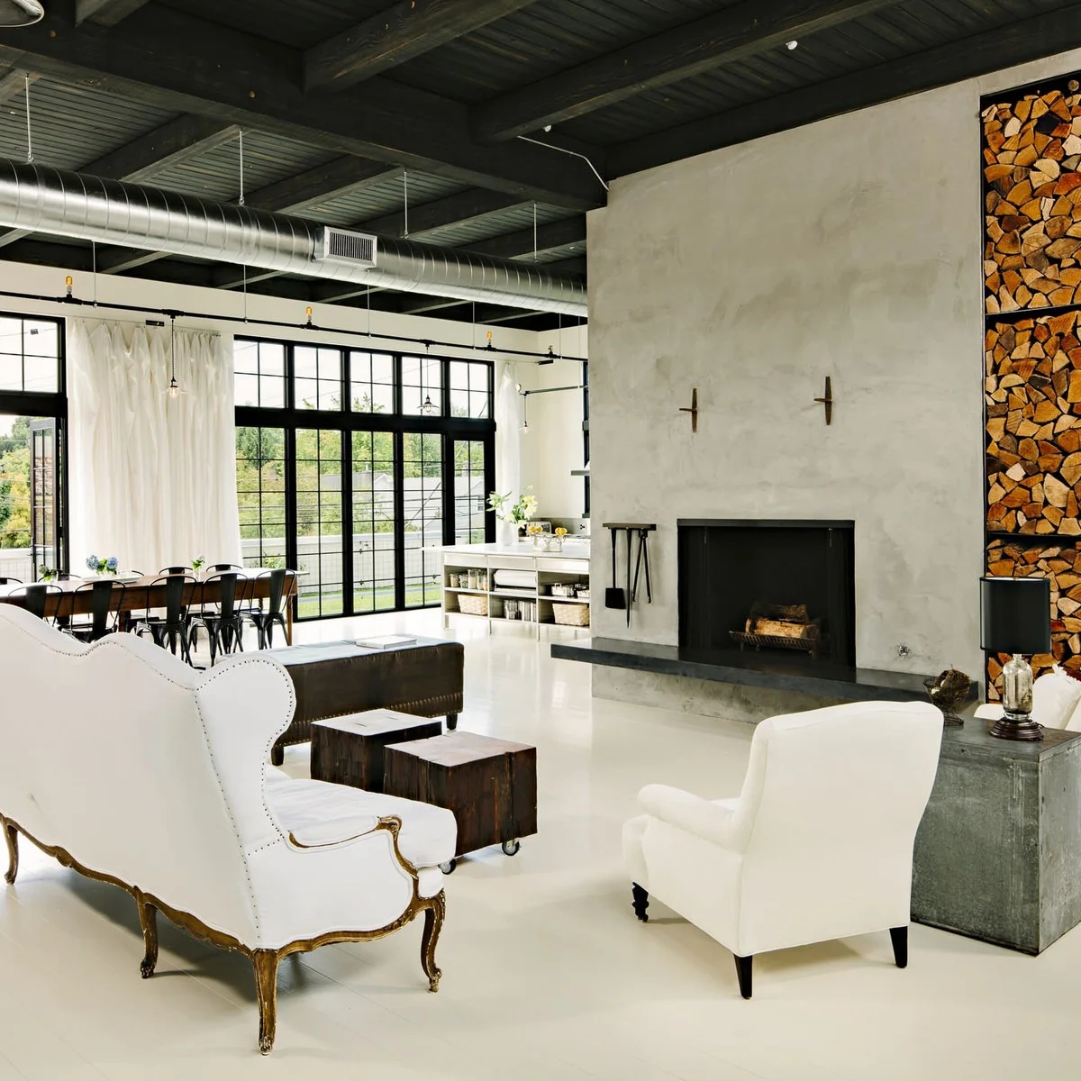 Dark painted boarded ceiling and beams above a bright room with white furniture