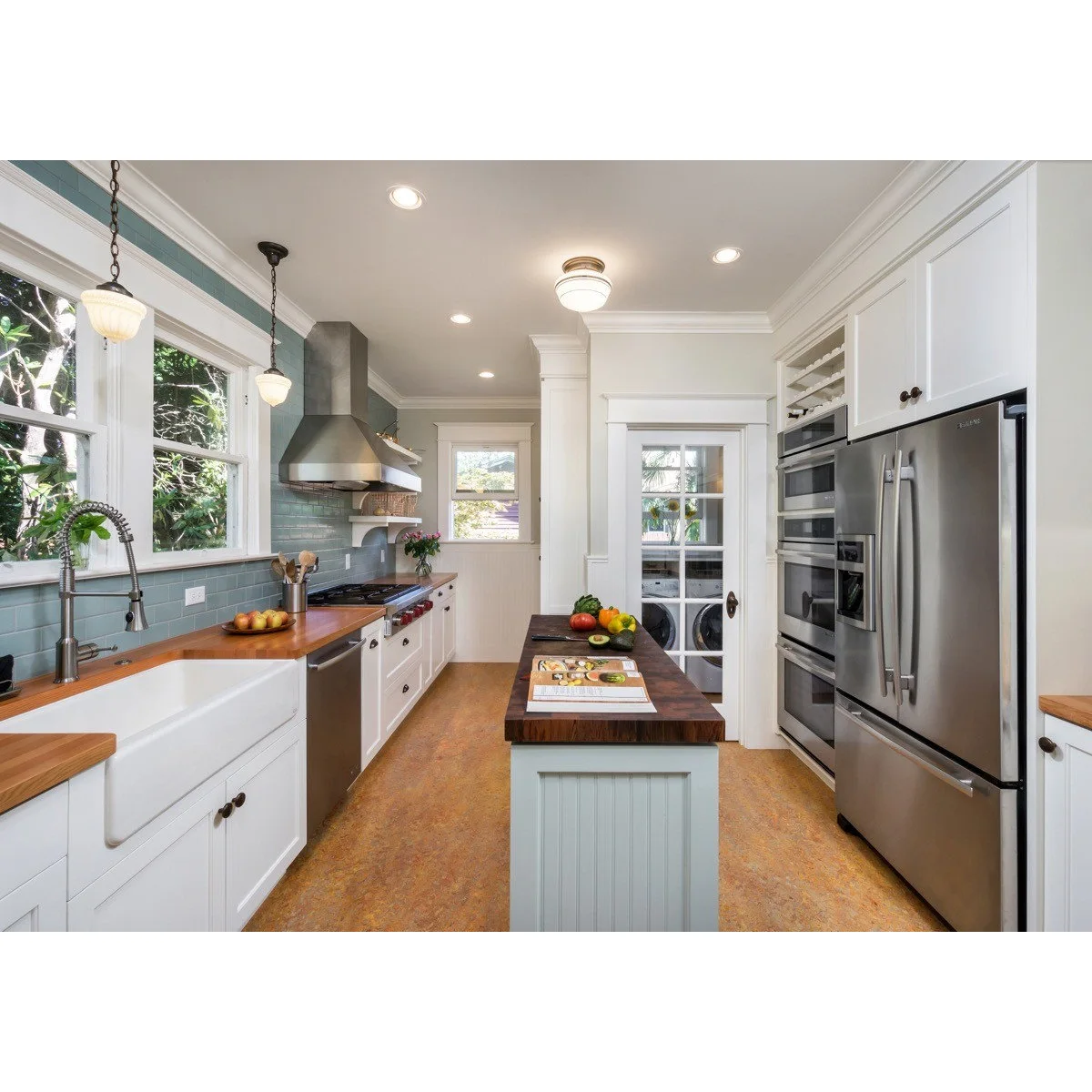 White galley kitchen with a slim freestanding prep unit opposite a long sink counter