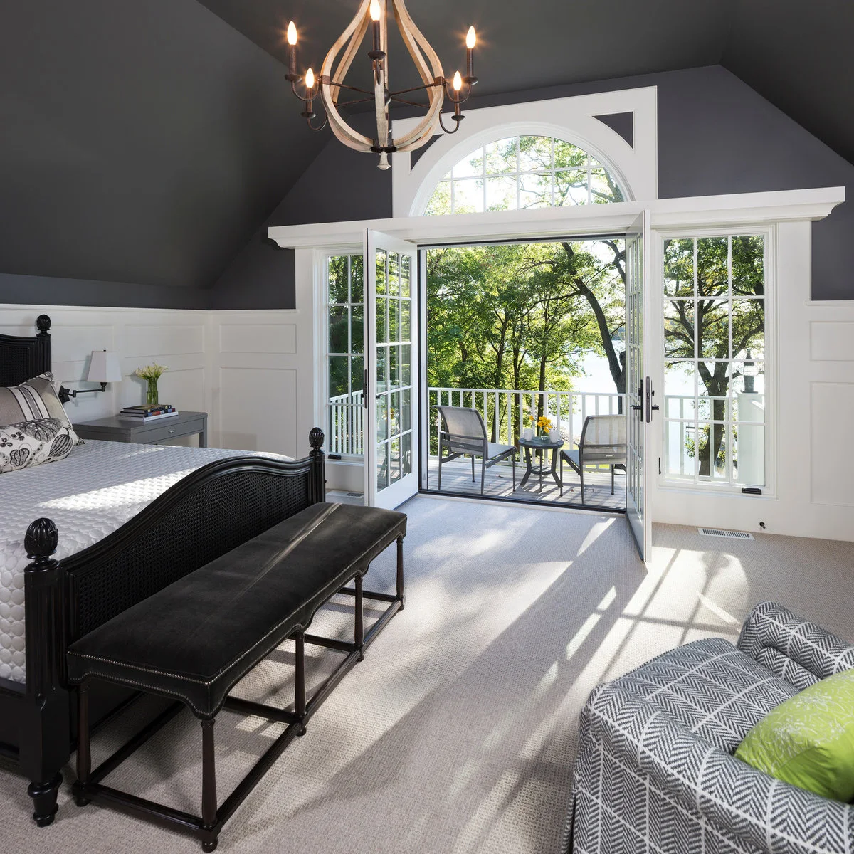 Charcoal upper bedroom walls and sloping ceiling above white lower panels and a dark bed