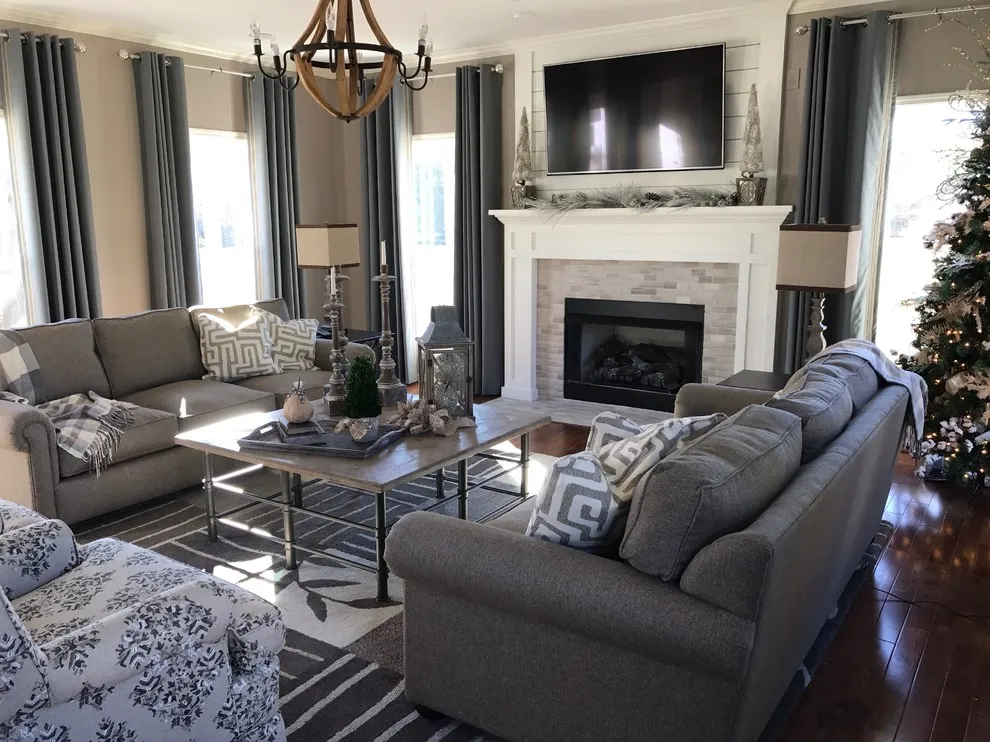 Two gray sofas sit around a dark coffee table on a pale geometric rug