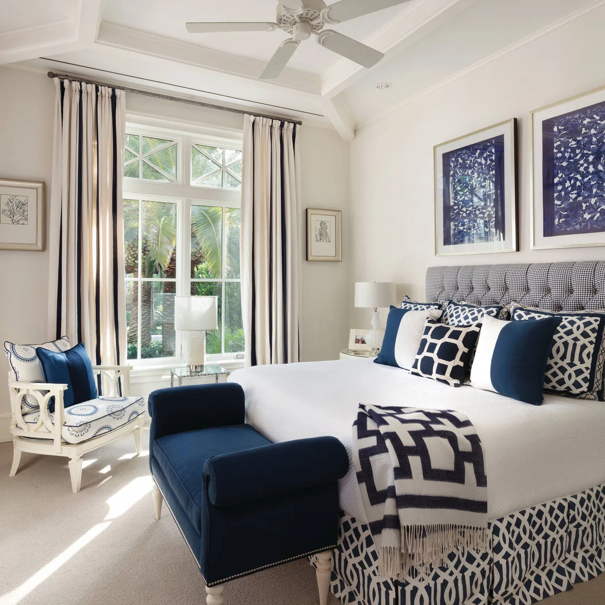 Navy bedroom bench with rolled bolster ends beside a blue-and-white bed
