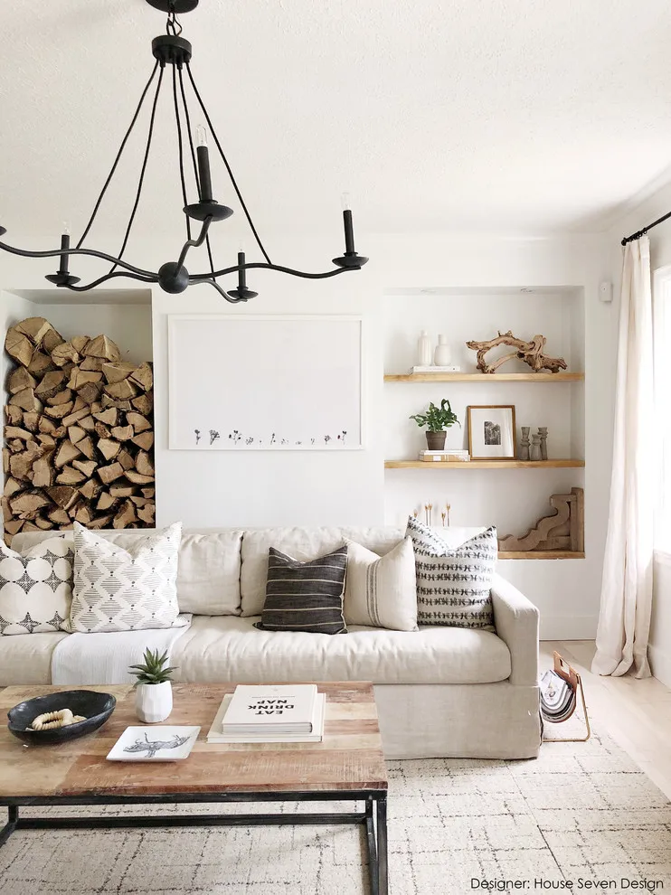 Beige sofa beneath timber shelves with books, pale cushions and a wood table