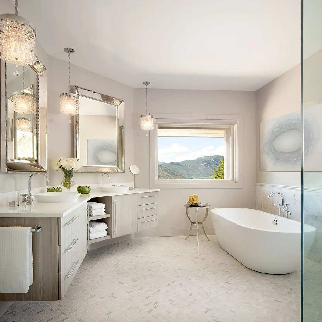A pale basketweave mosaic covers a bathroom floor between a freestanding white tub and a long vanity.