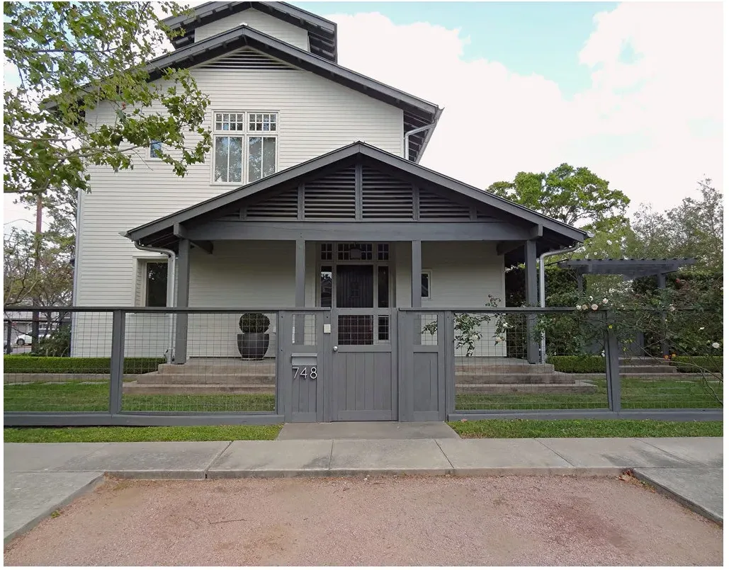 Gray-framed wire mesh panels and a matching pedestrian gate across a front lawn and house entrance.