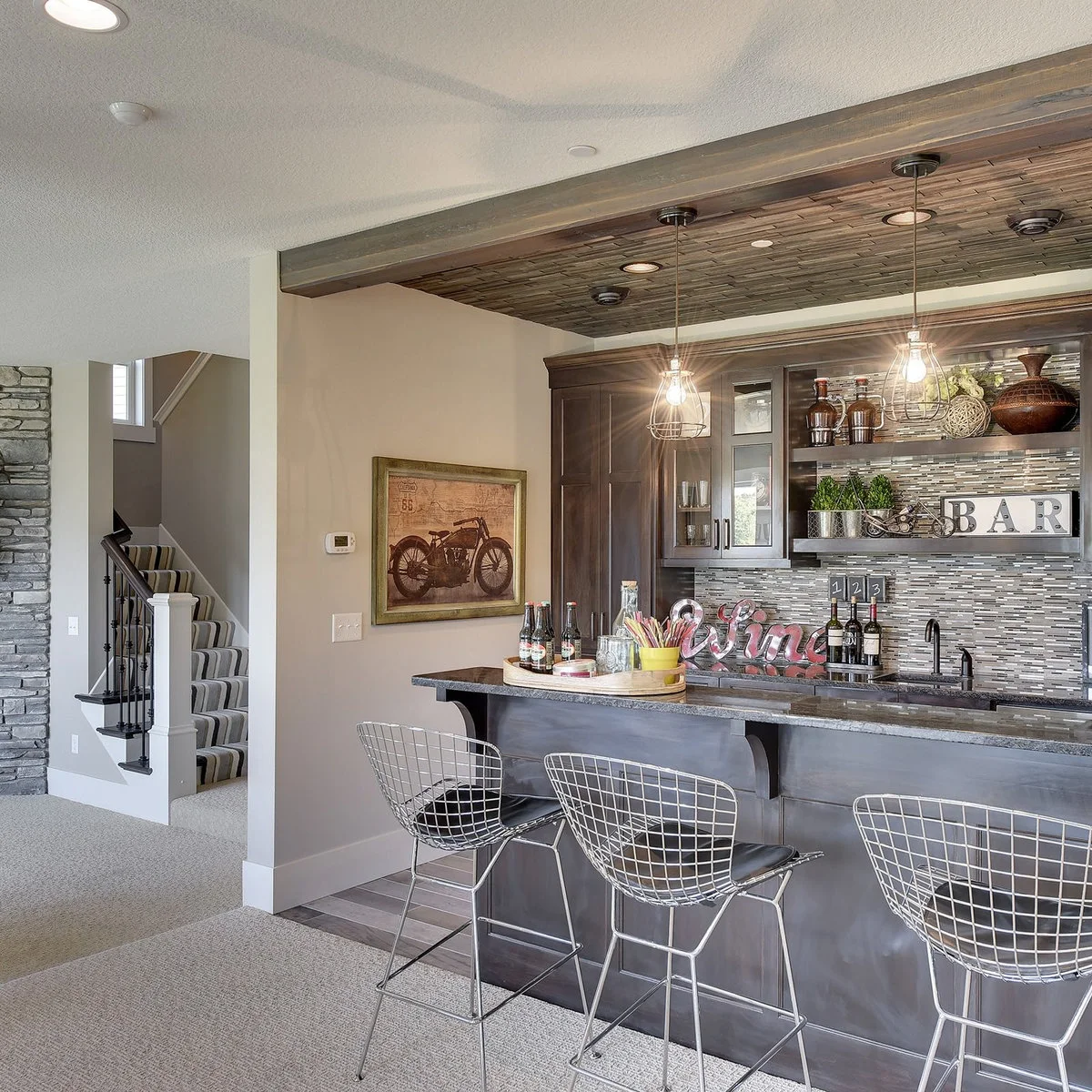 Basement bar with wood-colored ceiling inset, wire stools and mosaic-patterned backsplash