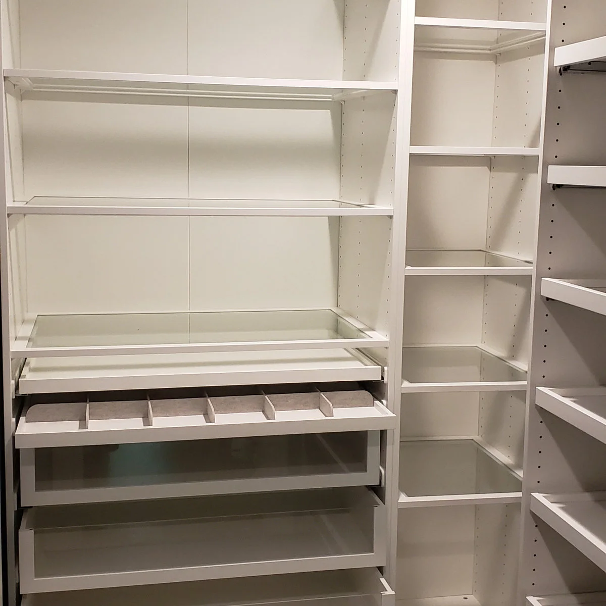 White PAX interior with shelves, glass-front drawers and a divided accessory tray