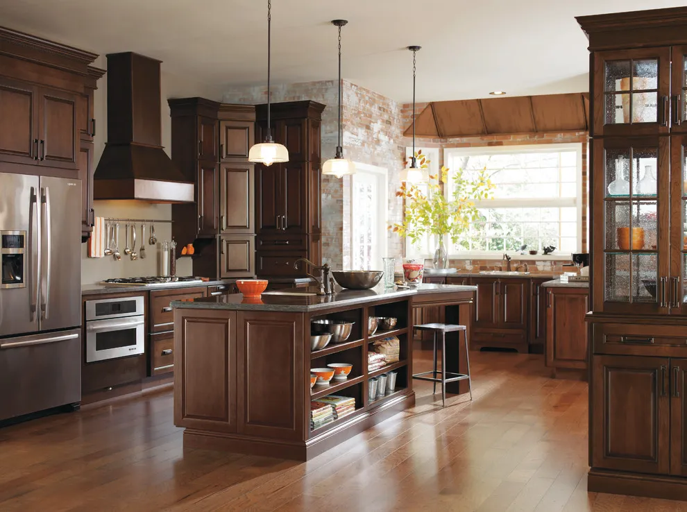 Dark wood cabinets frame a kitchen with a bright window and glass upper doors