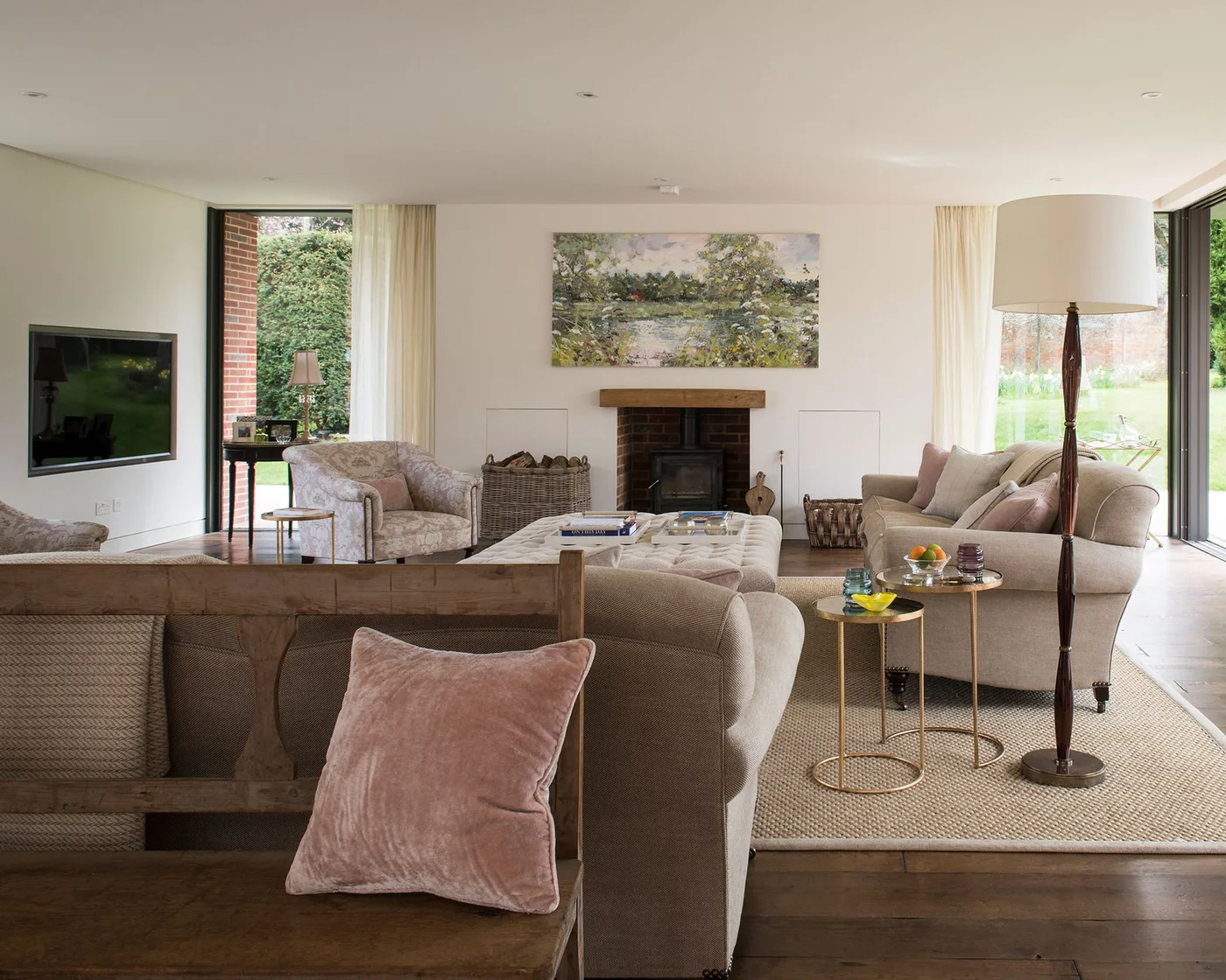 Neutral living room with TV on a side wall and artwork above the central fireplace
