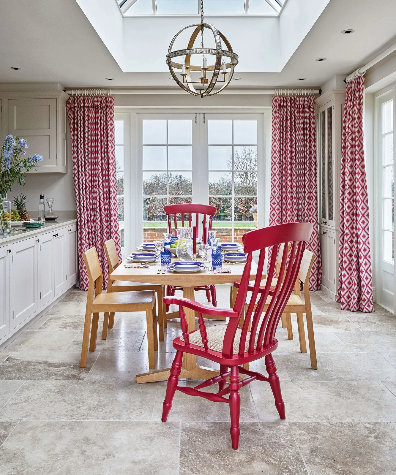 Red and white geometric curtains around glass doors beside a kitchen dining table