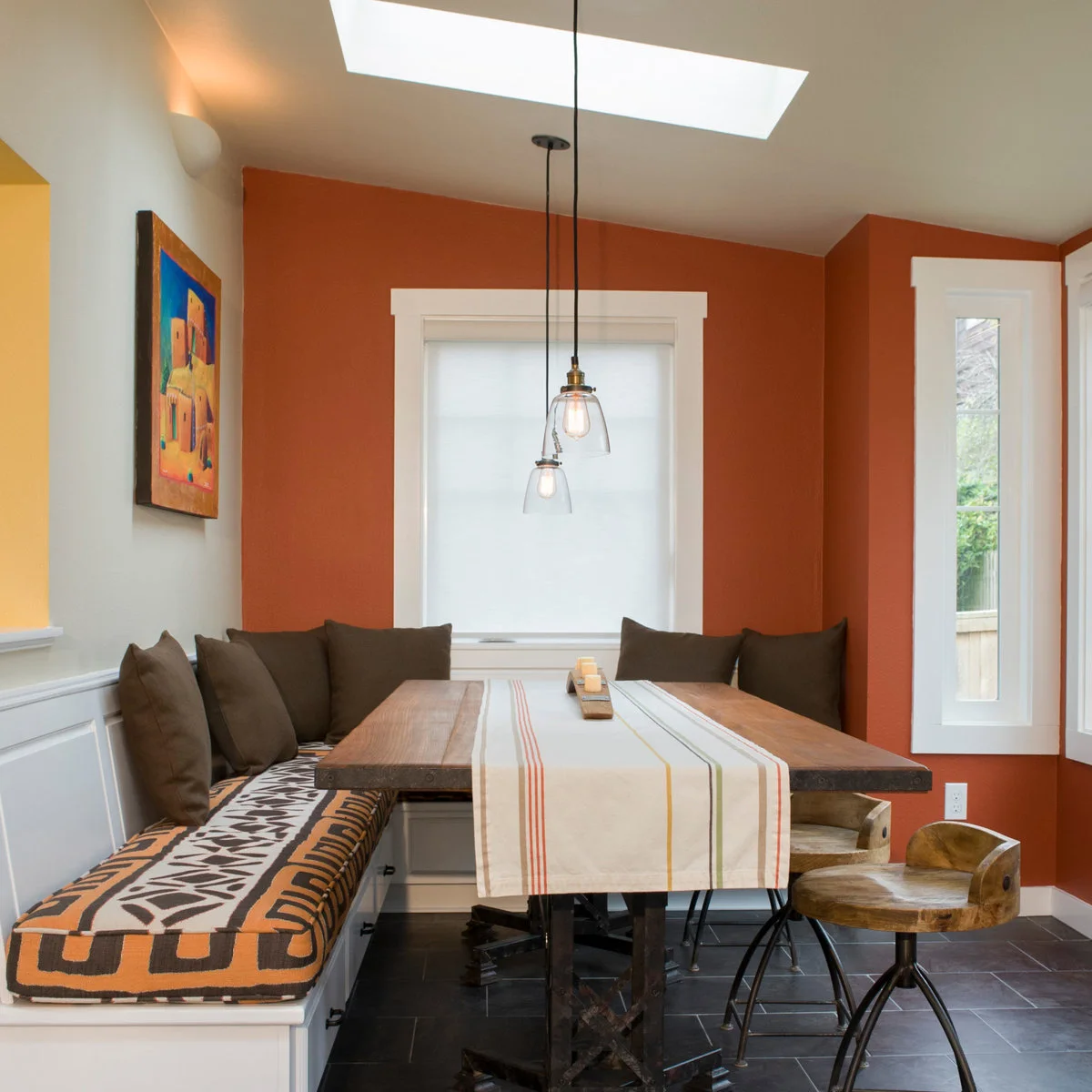 Small dining nook with cushioned corner benches and storage fronts beneath the seats