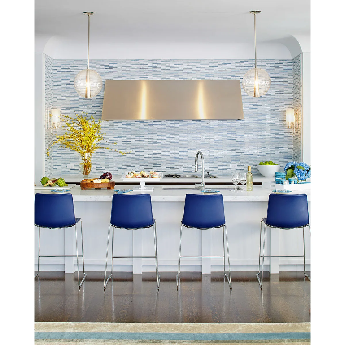 Blue kitchen stools with slim metal sled bases and simple curved seat backs