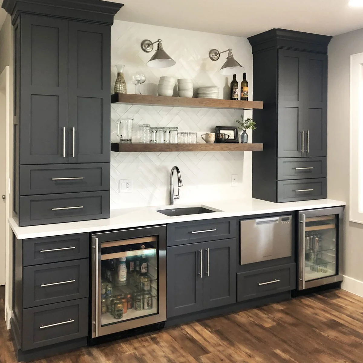 Dark gray basement wet bar with sink, two open shelves and glass-front undercounter appliances