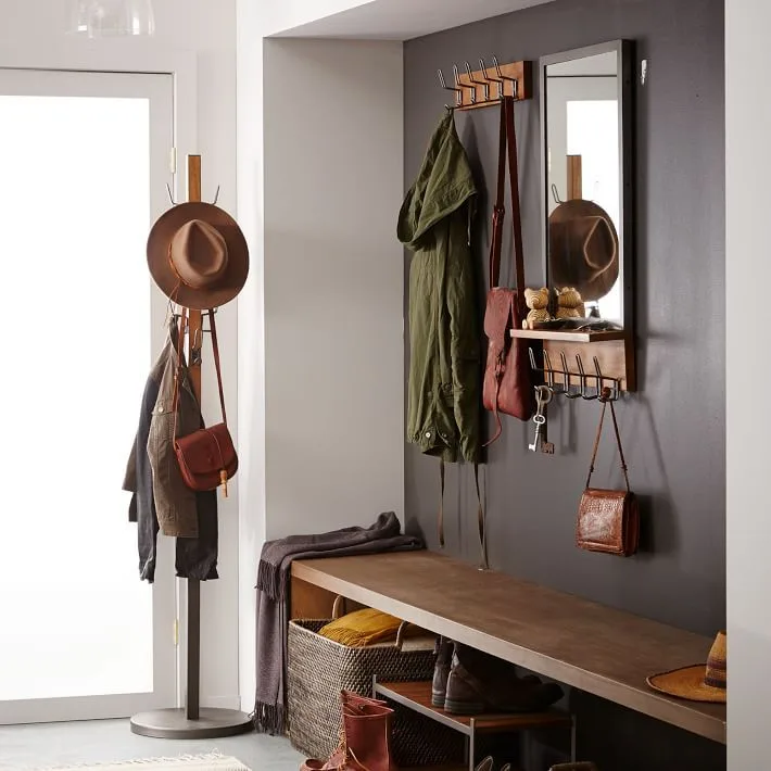 Gray entry corner with long wood bench, mirror and hook shelf, separate coat stand, lower shoe shelf, baskets and glazed door