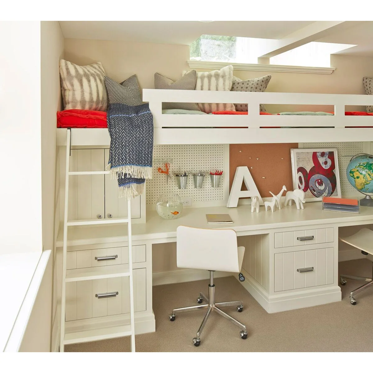 White built-in loft above two study places with pegboard cups, a central drawer unit and red bedding above.