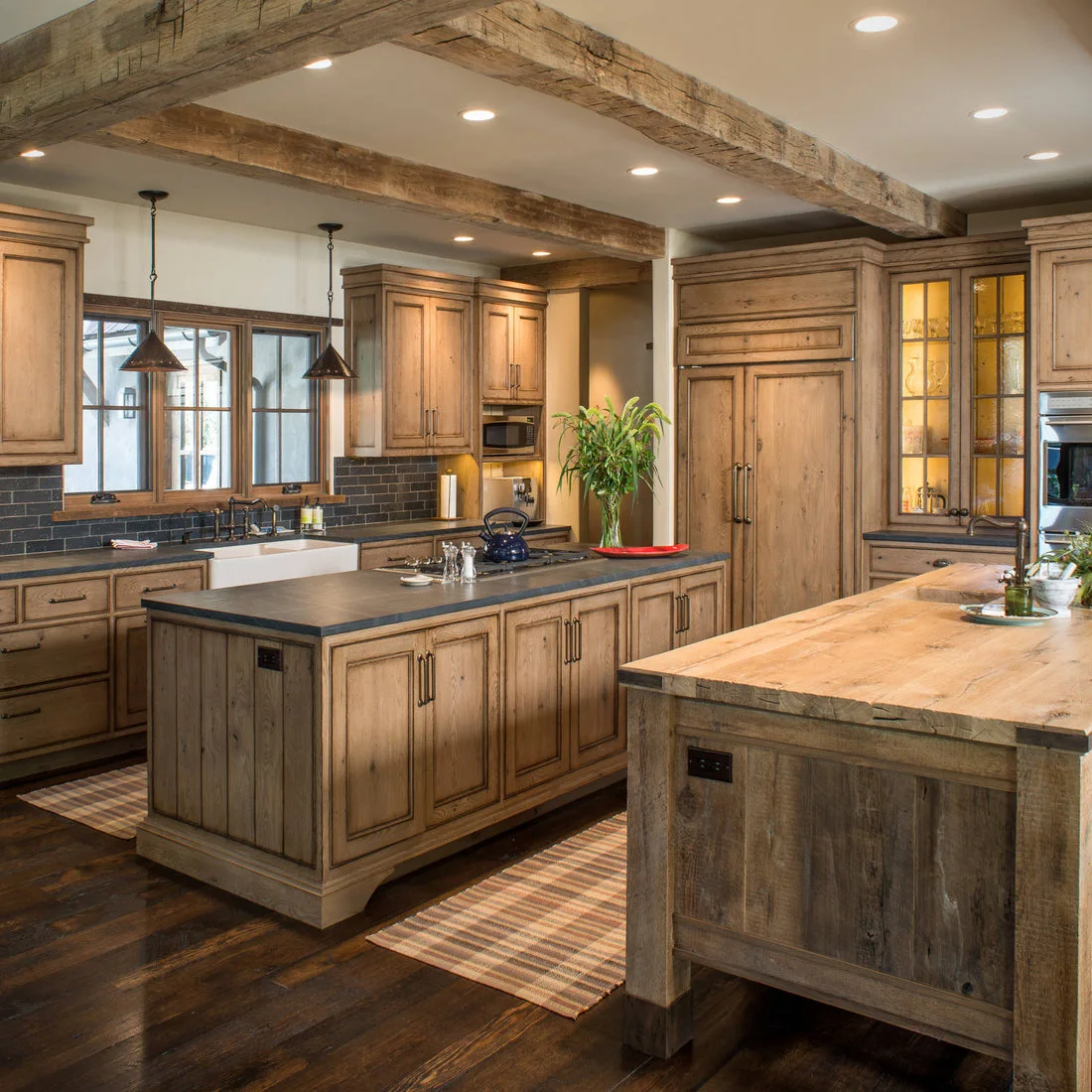Two timber kitchen islands, one with a dark counter and one with a broad wood top