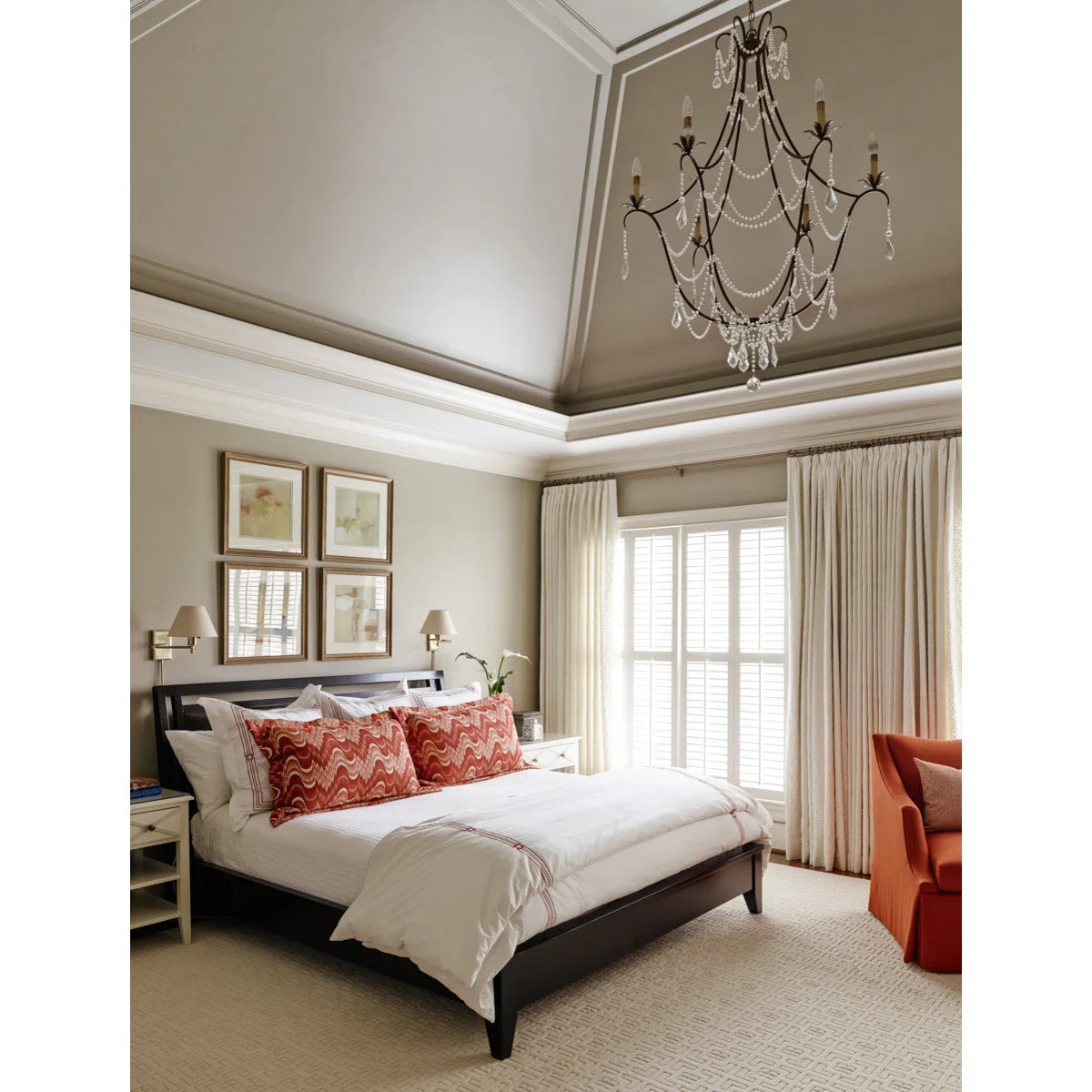 Greige bedroom walls and a tall painted ceiling with white molding, white bedding and coral pillows.