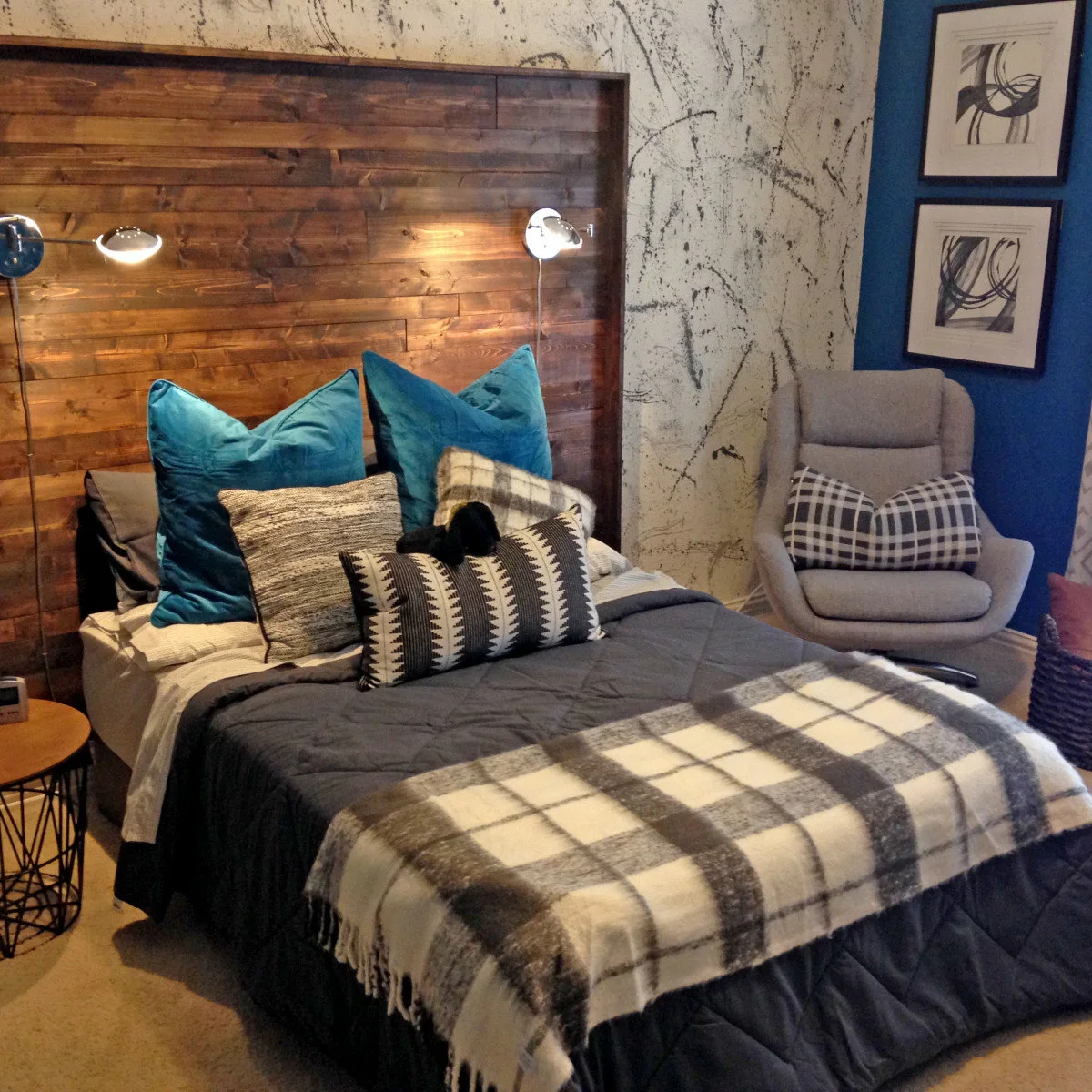 Teen bedroom with a wood-colored feature headboard, splatter-patterned wall and gray swivel chair