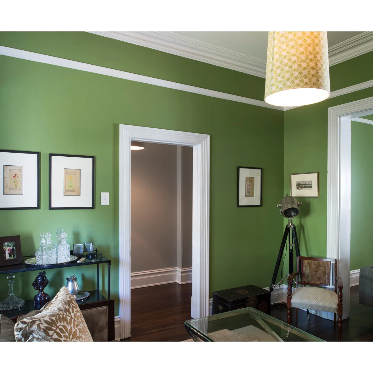 Green Balmain terrace room with a wide doorway, slim console and chair near the opening