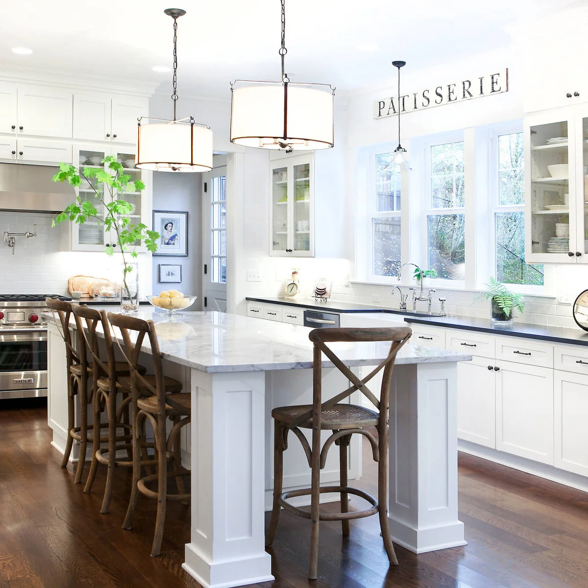 Wood kitchen stools with cross backs, woven-looking seat centers and circular lower rails