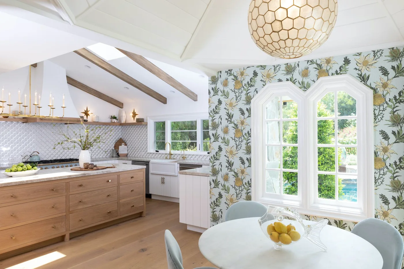 White and wood country kitchen with yellow floral wallpaper around dining-area window