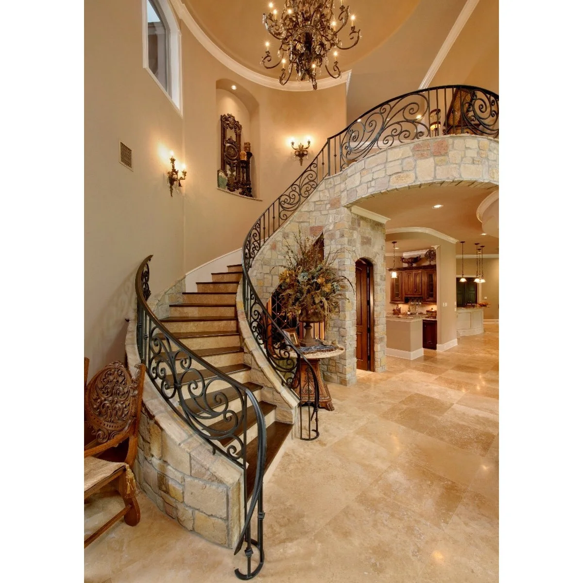 Curved staircase with dark scroll-pattern railing, warm steps and a stone-faced stair wall