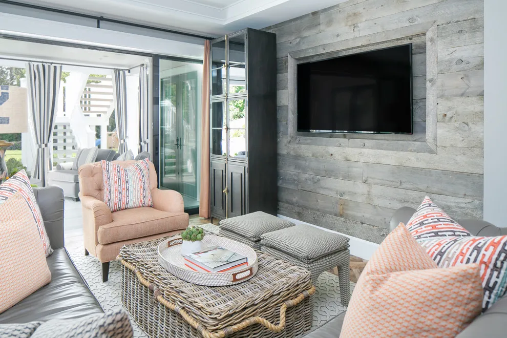 Pale horizontal wood boards surround a television beside soft pink seating
