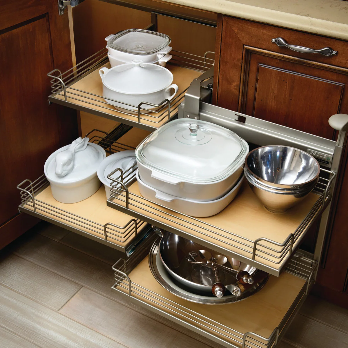 Corner fitting with rectangular pull-out trays holding white serving dishes and mixing bowls