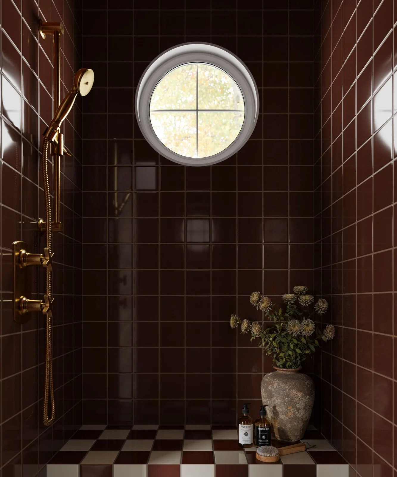 Deep red-brown square tiles surround a round shower window beside brass-colored fittings and a tiled ledge