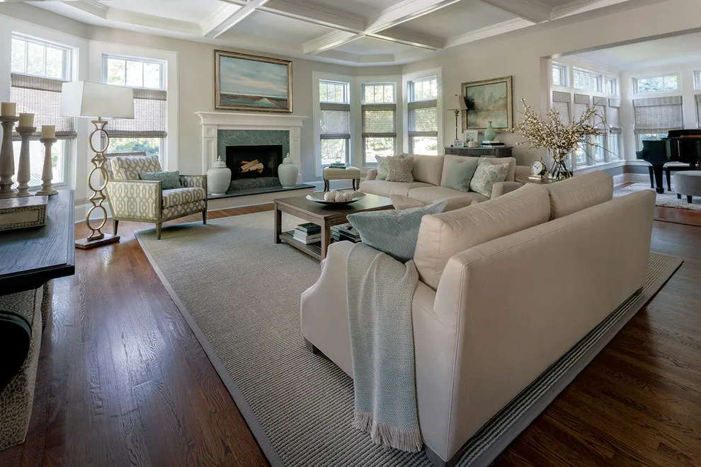 A long beige sofa faces a coffee table on a pale rug in a spacious room
