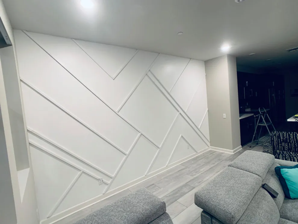 Angled strips create a geometric pattern on a white wall behind gray seating