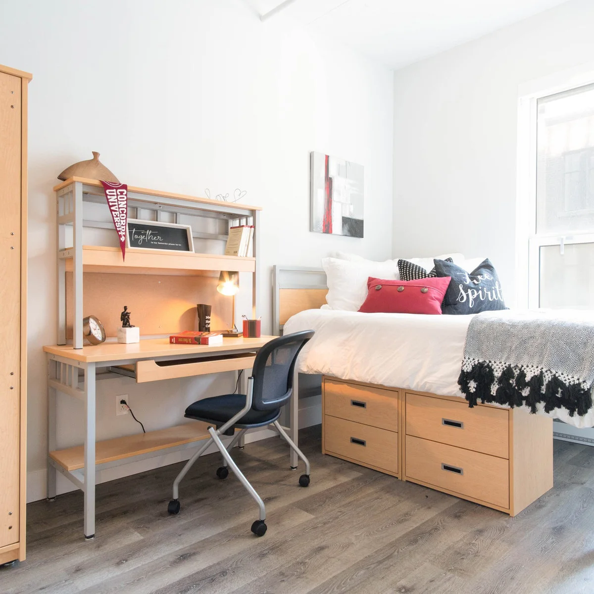 Student bedroom with a wood-and-metal desk, shelf hutch and bed beside four under-bed drawers