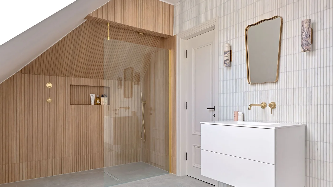 Reeded wood-effect shower tiles meet white ribbed wall tiles beside a floating white vanity.