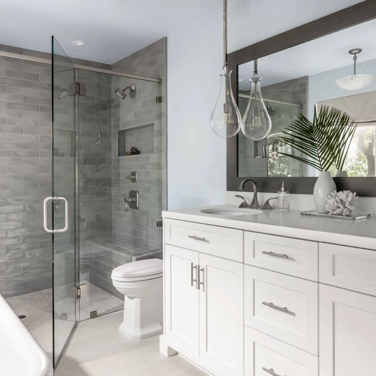 White vanity with a gray rectangular tray holding a white vase and leafy stem at the far end.