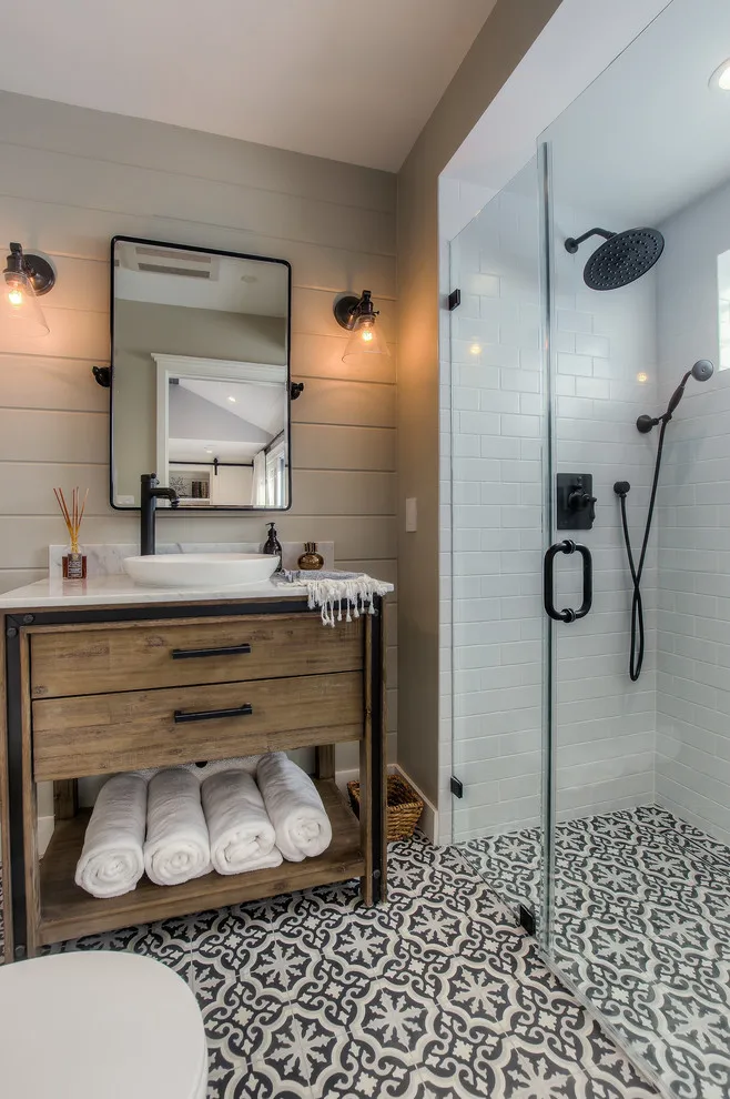 Black-and-white patterned floor tiles sit beneath a timber vanity and glass shower