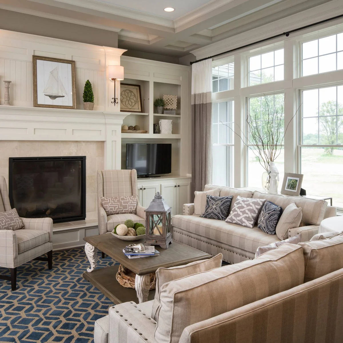 Two display shelves with framed art, books and pale objects above a television in a side alcove beside a fireplace.