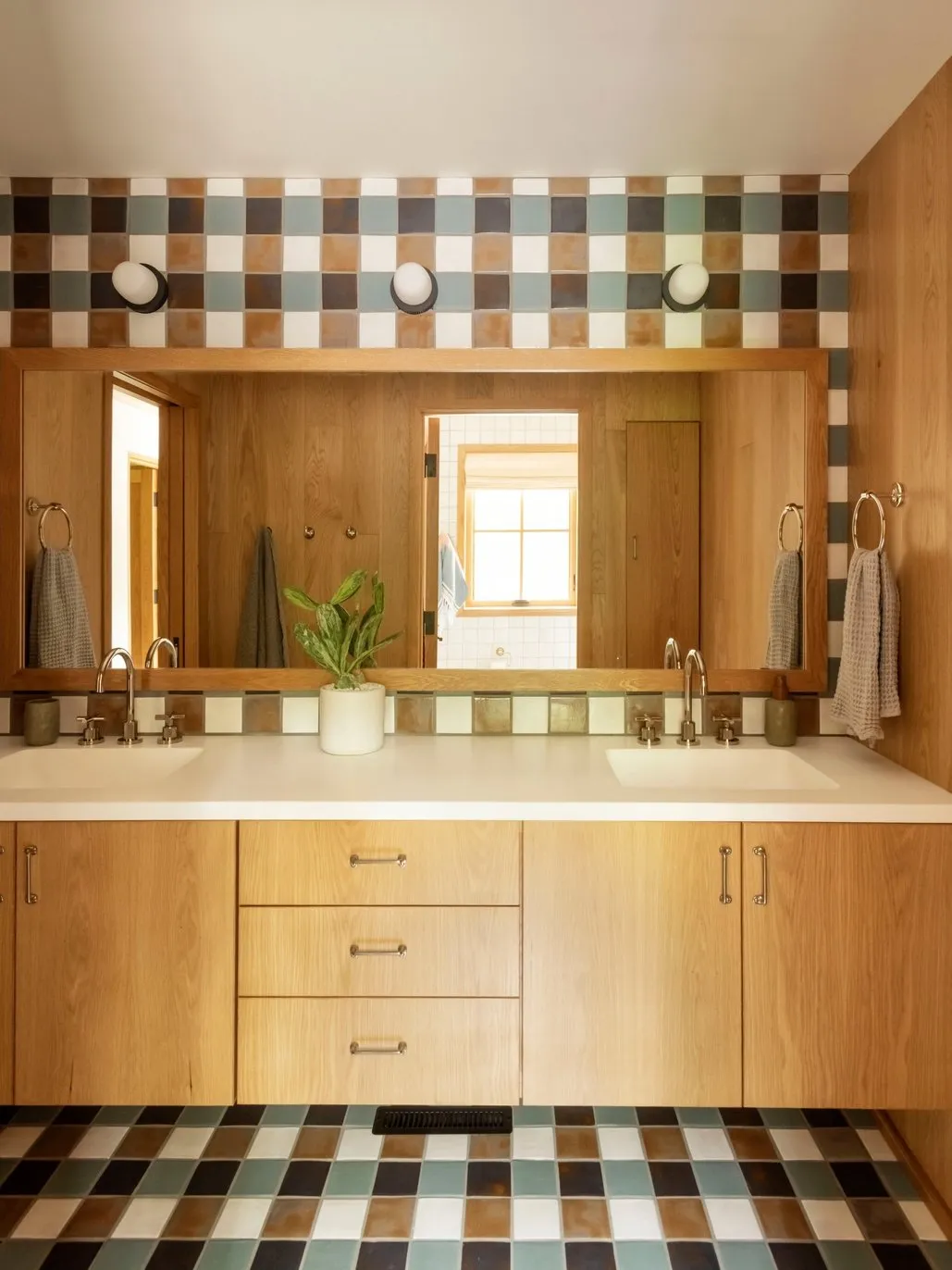 A checkered floor sits below a timber vanity with a related tiled band above the mirror