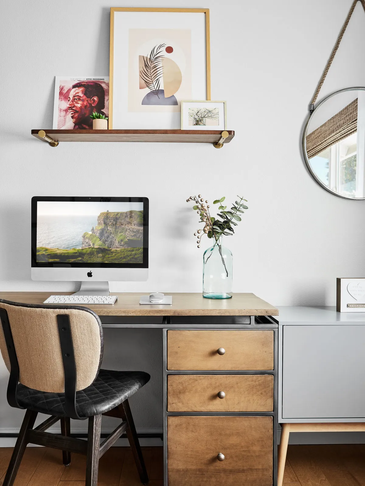 A small desk with timber drawers sits below a simple display shelf.