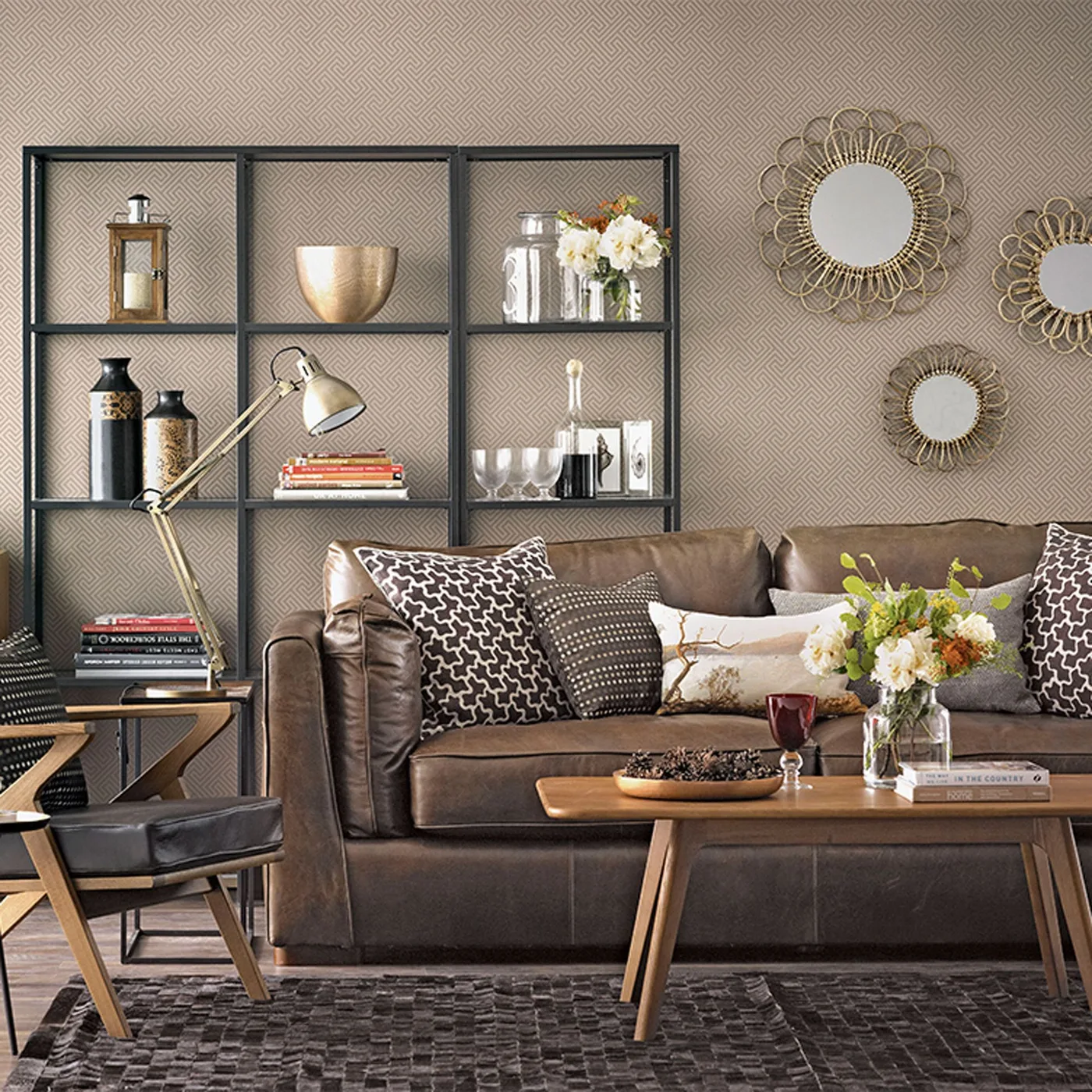 Dark brown couch with dark geometric square pillows and a pale horizontal pillow beside open shelving.