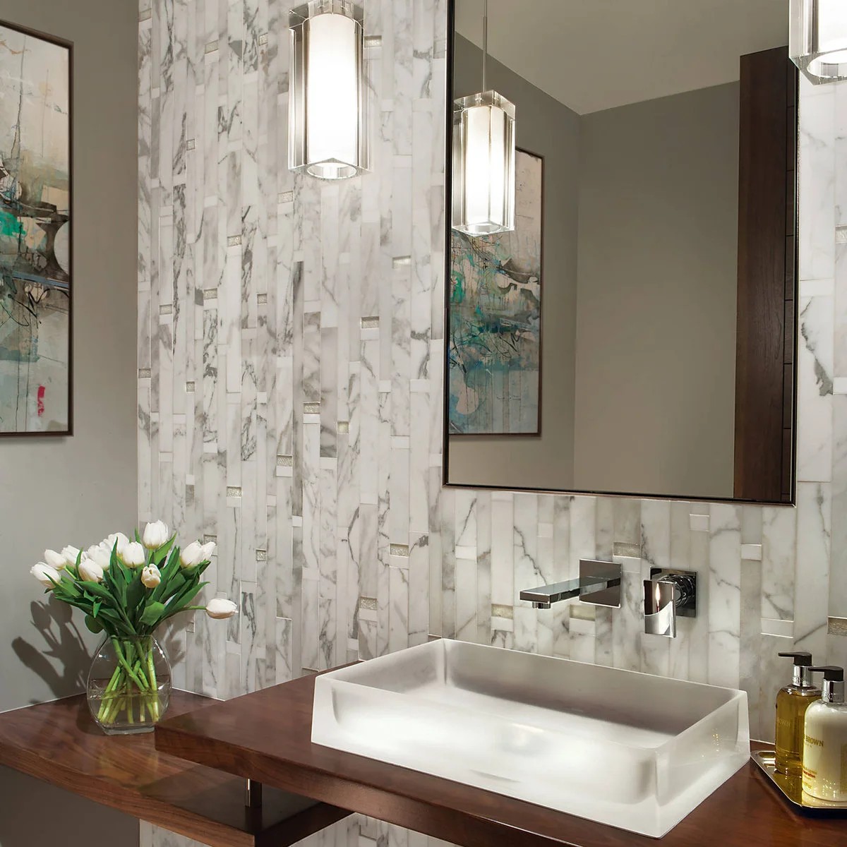 A white rectangular vessel basin stands on an open wood counter below a wall-mounted faucet and tall mirror with pale patterned tiles.