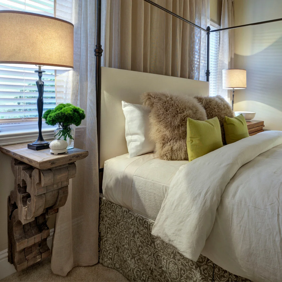 Rustic wall-mounted wooden bedside ledge on a carved bracket beside a canopy bed