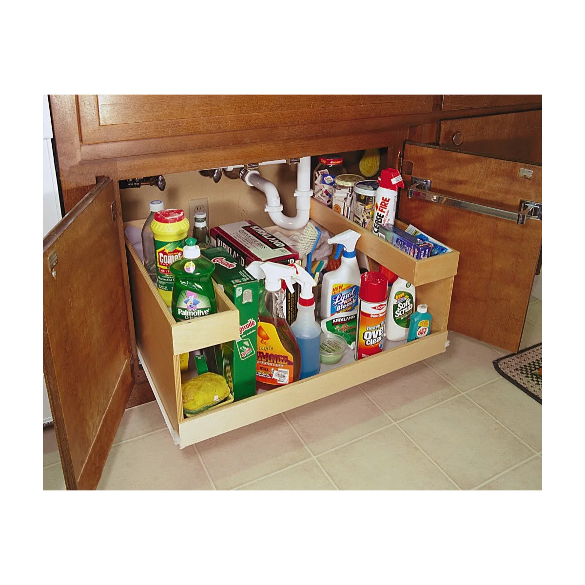 Under-sink cupboard with a shaped pull-out holding cleaning bottles around the drainpipe