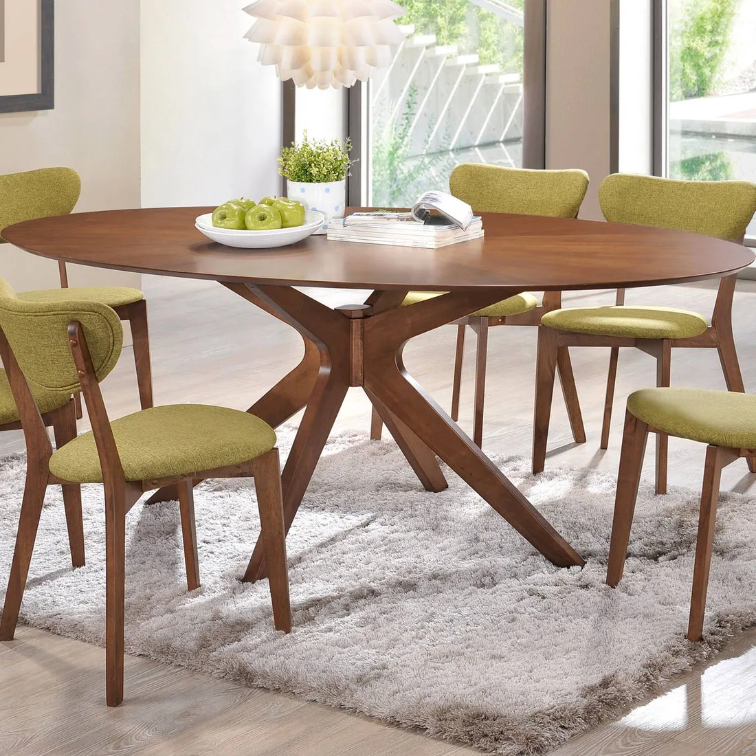 Wood oval dining table with a branching base, green upholstered chairs and a pale rug
