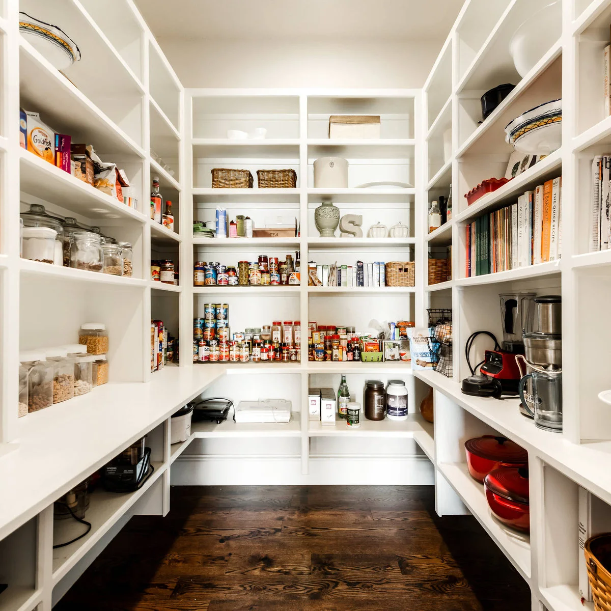 White walk-in pantry with open shelves, small appliances and an unobstructed wood floor