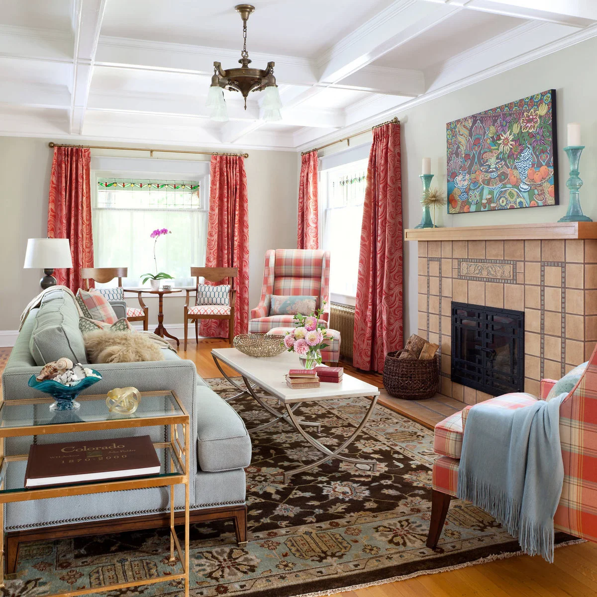 Long green-sofa living room with plaid chairs, a narrow white coffee table and a small window table