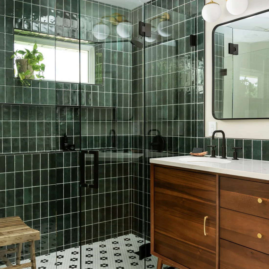 Black flower motifs repeat across a pale mosaic bathroom floor below green shower walls and a timber vanity.
