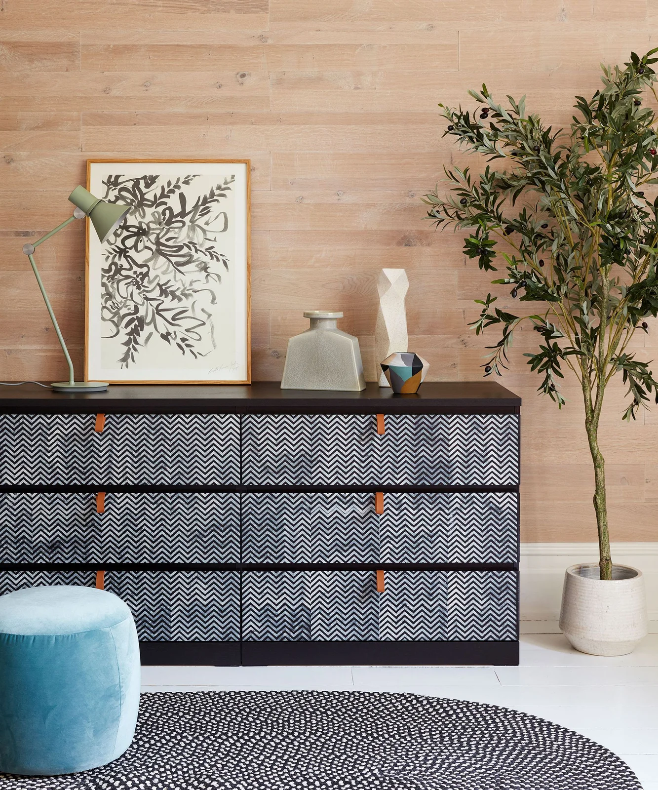 Wide dark chest with black-and-white chevron-pattern drawer fronts and tan tab handles