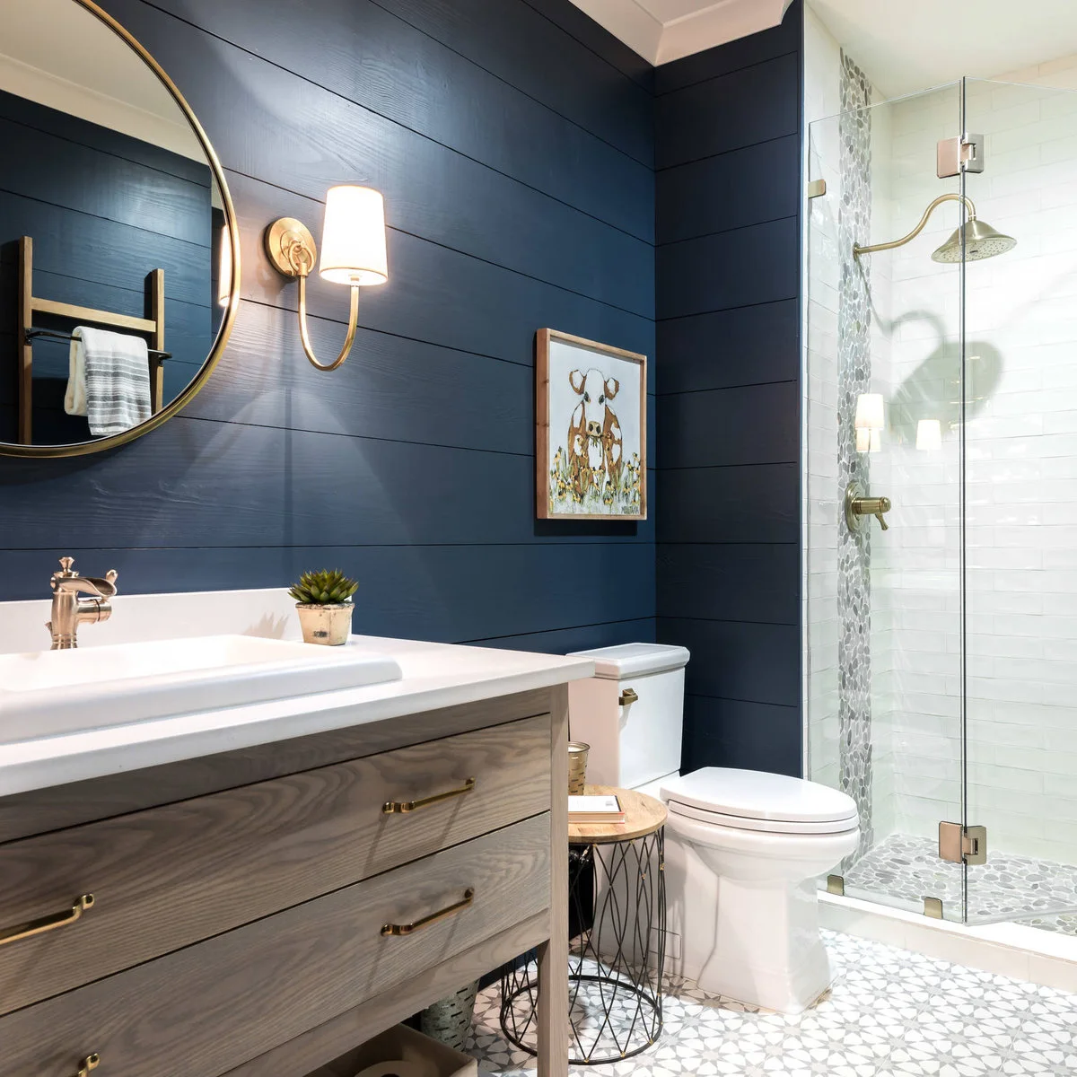 Small dog picture on dark blue bathroom paneling beside a glass shower
