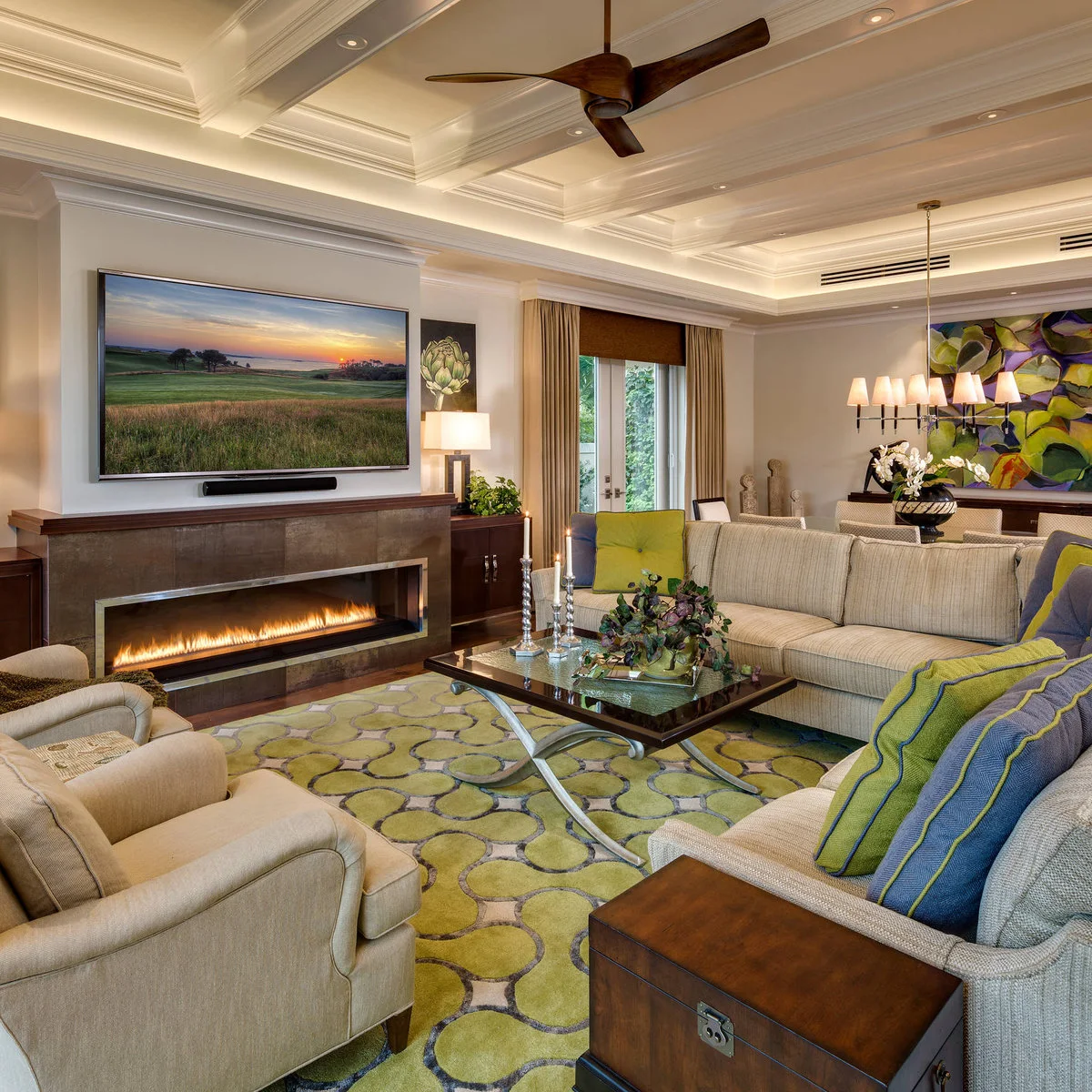 A pale sofa and chairs surround a dark table on a lime patterned rug, with a dining table behind the sofa.